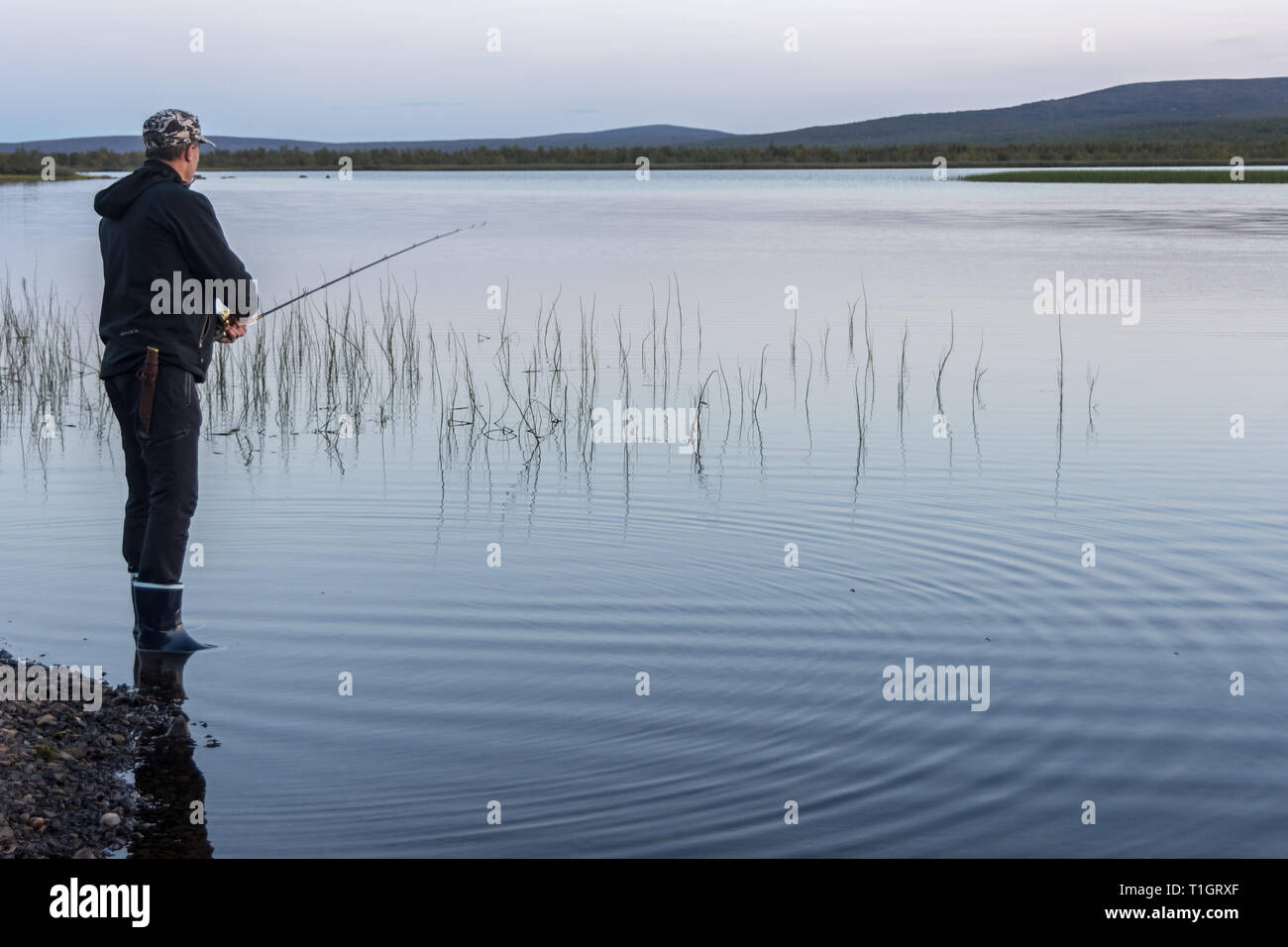 Fisherman by the lake in Lapland, Finland Stock Photo