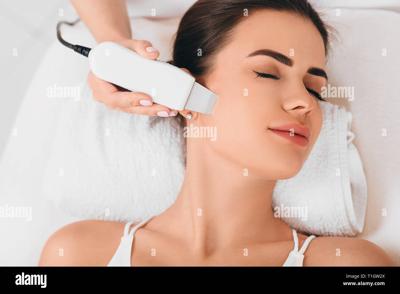 Beautiful woman receiving ultrasonic facial exfoliation at spa Stock Photo