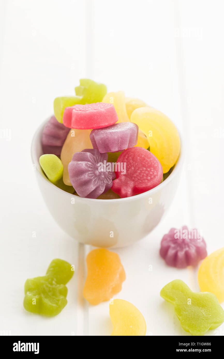 Fruit jelly candies in bowl on white table. Stock Photo