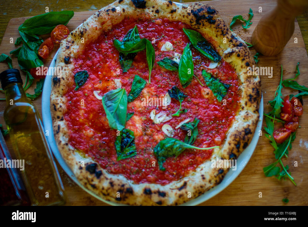 Vegan wood fired pizza. A traditional authentic neapolitan style wood fired pizza on table in a pizzeria trattoria restaurant. Vegan marinara. Stock Photo
