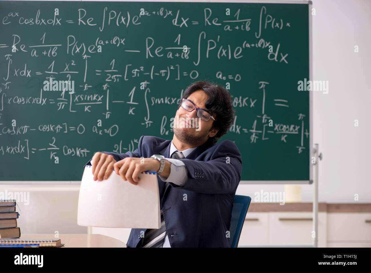 Young male math teacher in classroom Stock Photo