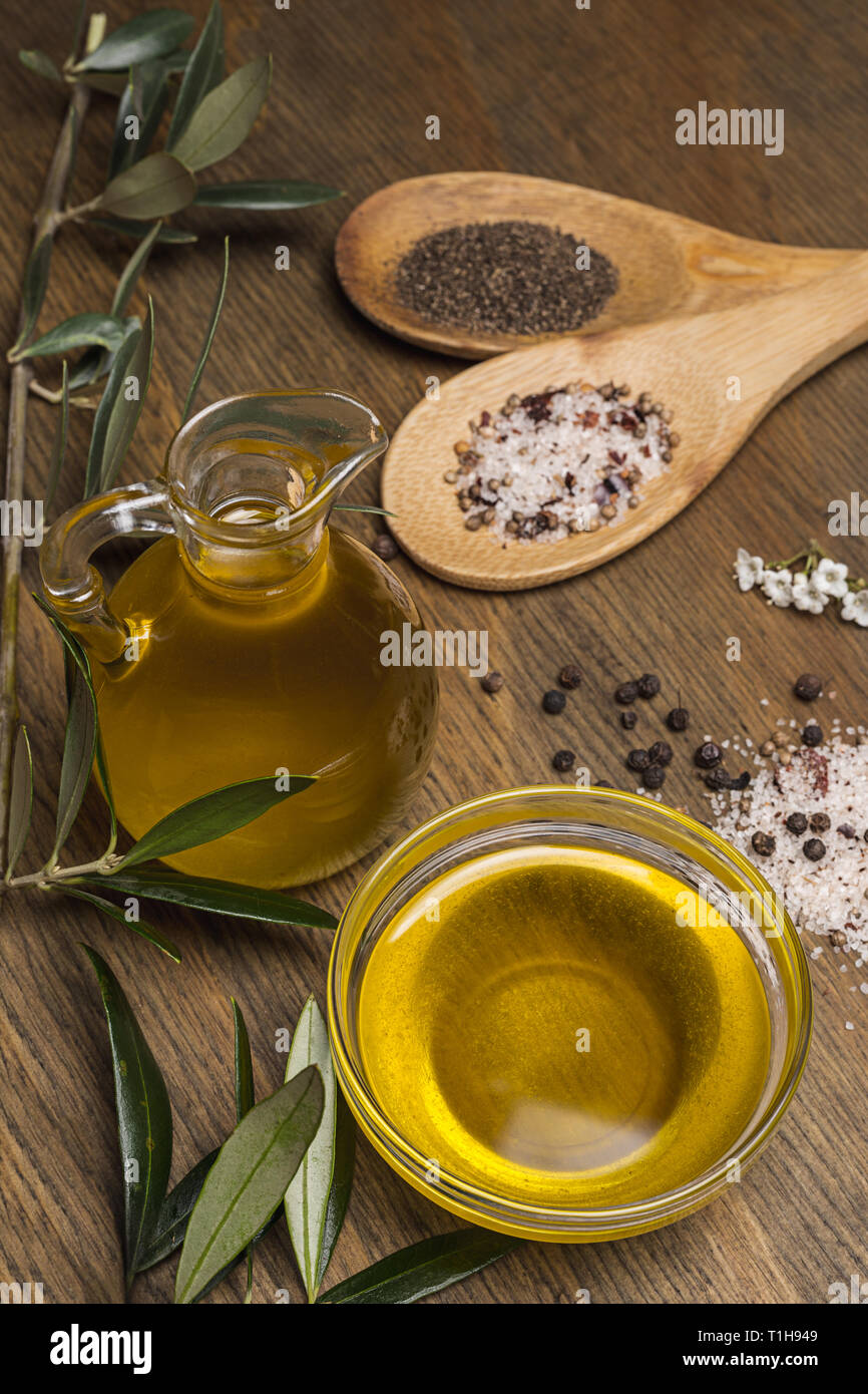 Olive oil, two spoon with salt and pepper on a wooden table Stock Photo ...