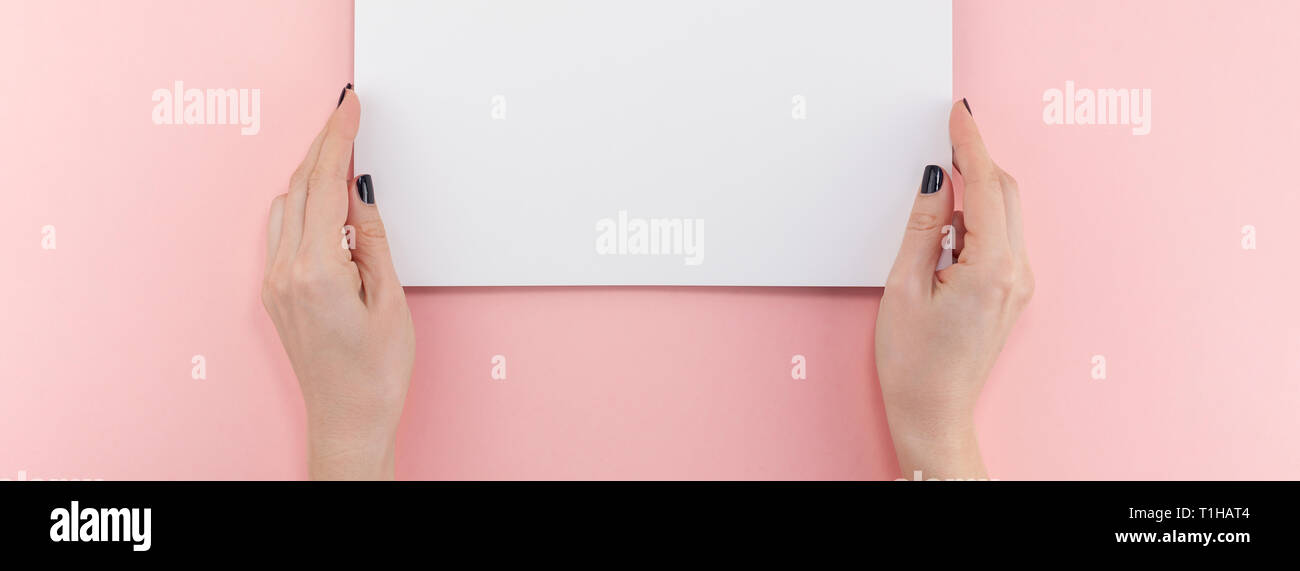 Creative flat lay top view of woman hands black manicure with empty A4 ...