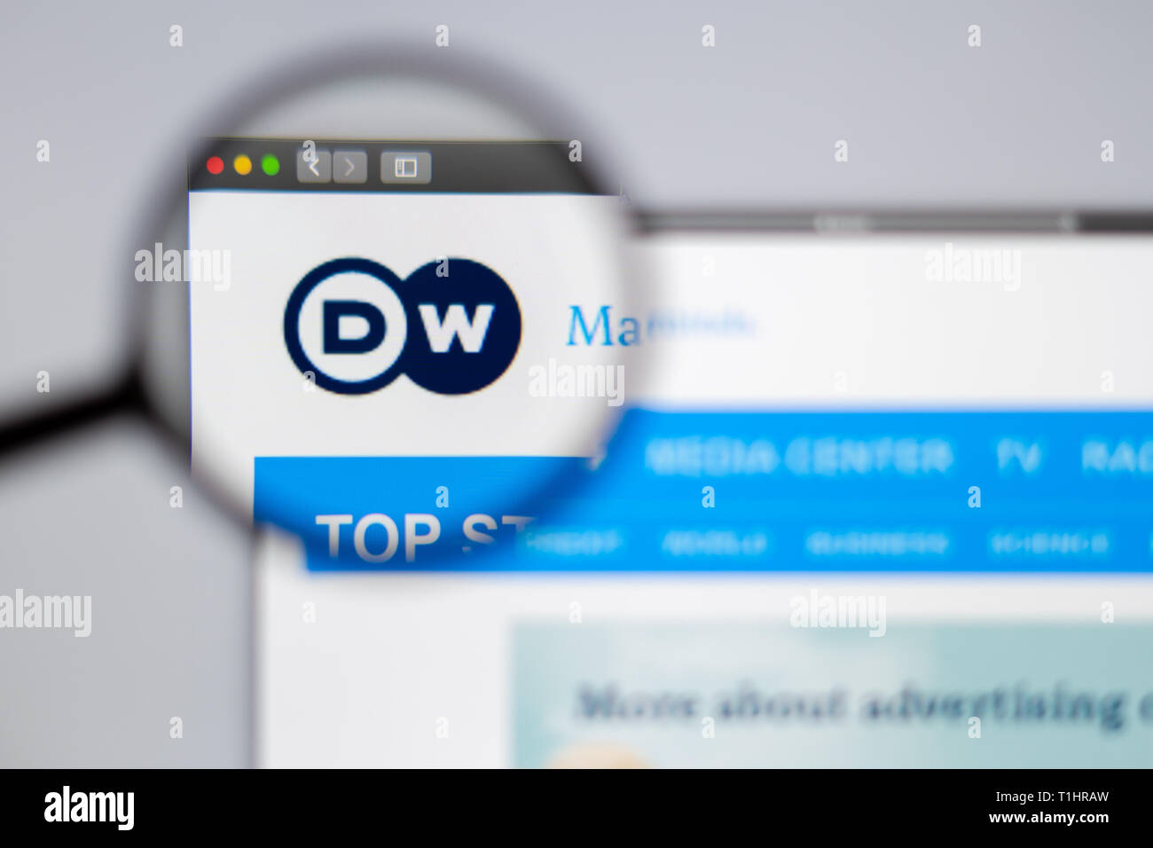 Germany news media Deutsche Welle website homepage. DW logo visible  through a magnifying glass. Stock Photo