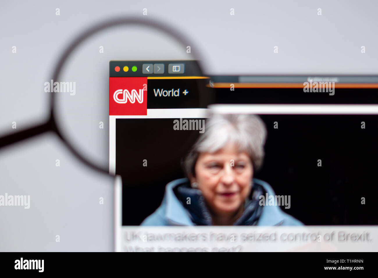 CNN website homepage. CNN channel logo visible through a magnifying