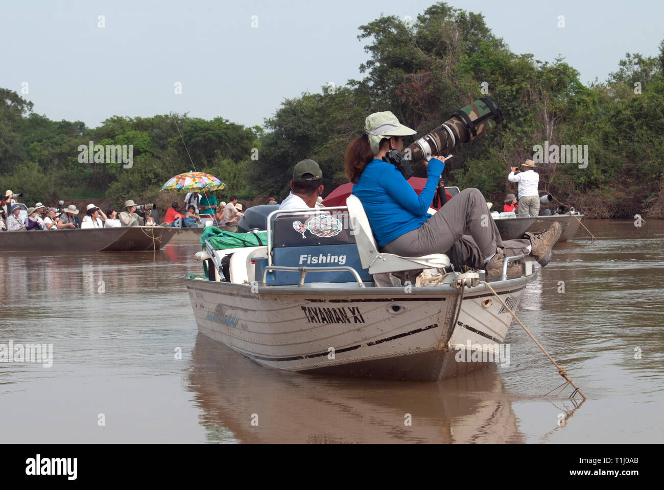 Photographers in boats waiting for a jaguar to wake up in The Pantanal in Brazil Stock Photo