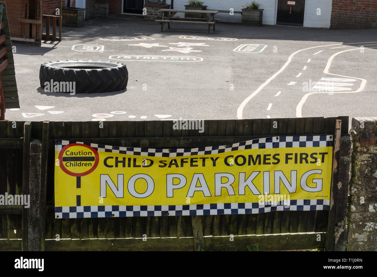 Sign or banner saying Child safety comes first - No Parking, outside an infant school in Surrey, UK. School safety concept. Stock Photo