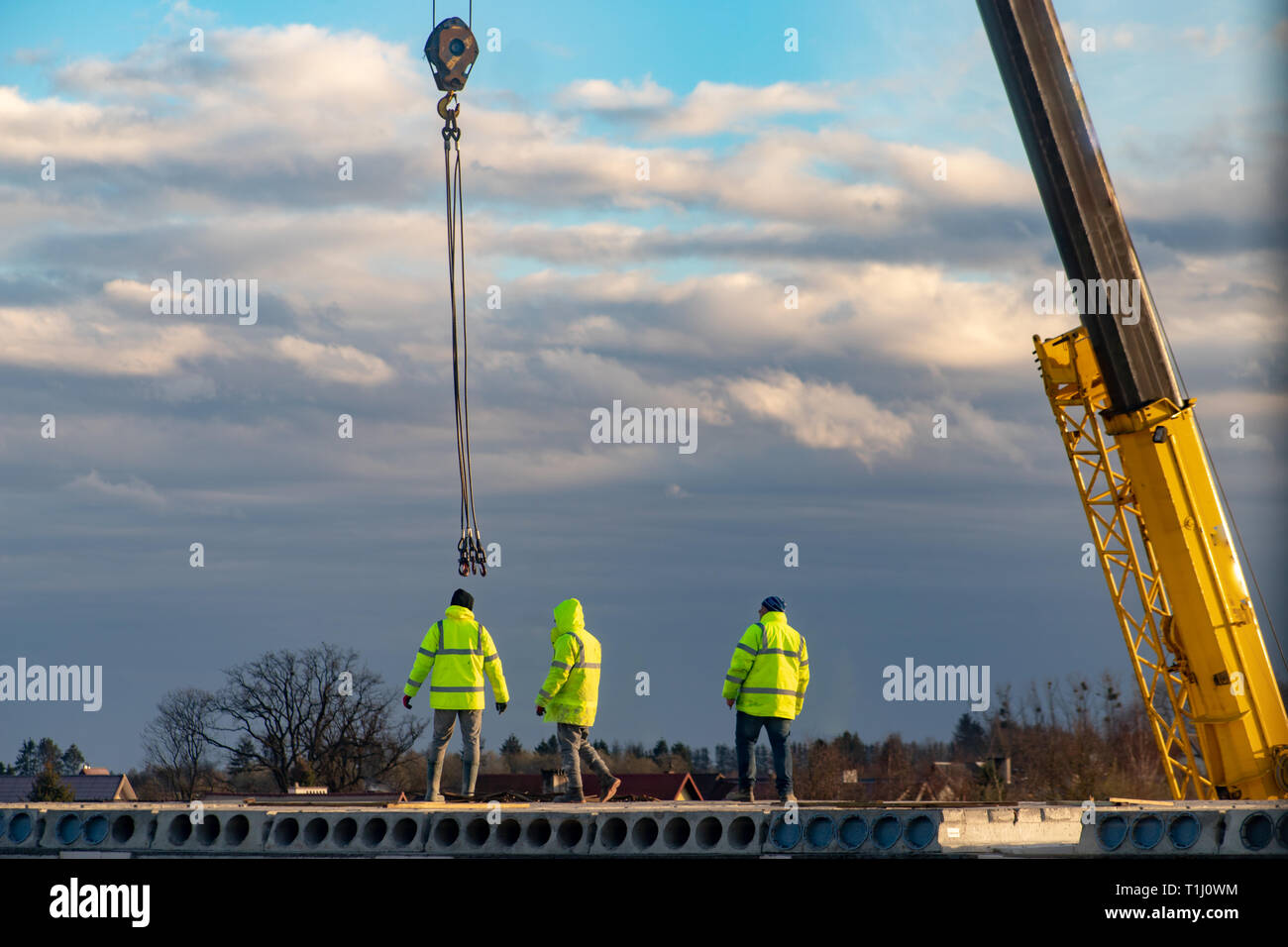 Employees working on the construction of a block of flats. Construction works on house construction. Season of the spring. Stock Photo