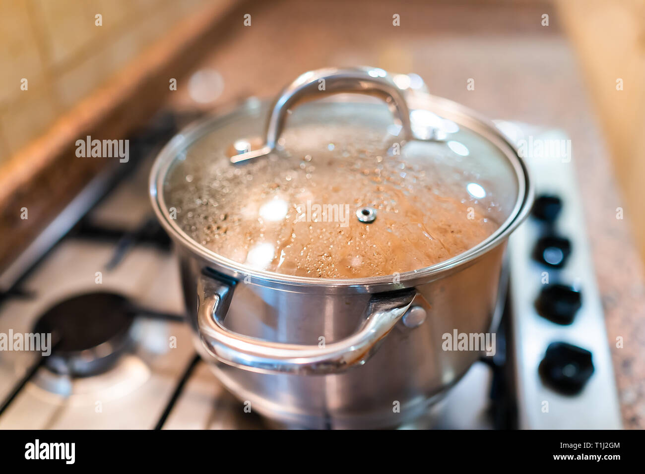 Boiling water in pan. Cooking pot on stove with water and steam