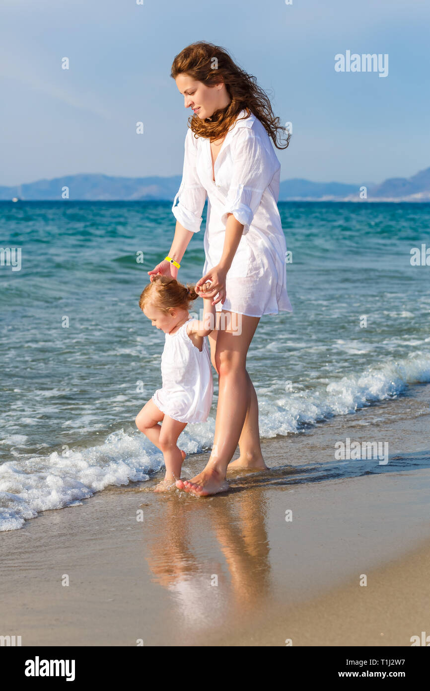 Mother and daughter walking on the beach Stock Photo