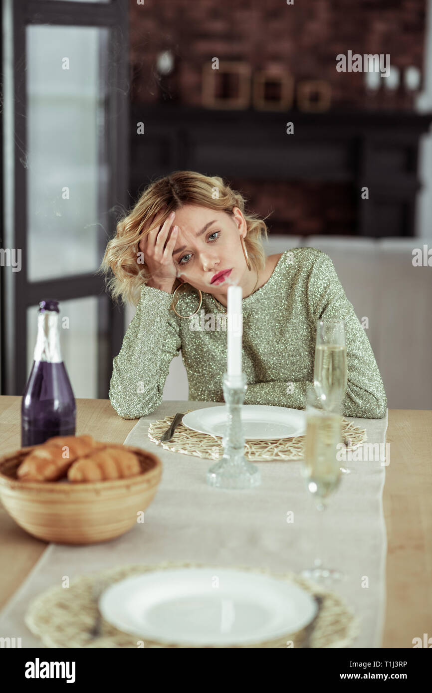 Curly blonde wife feeling melancholic staying alone at home Stock Photo