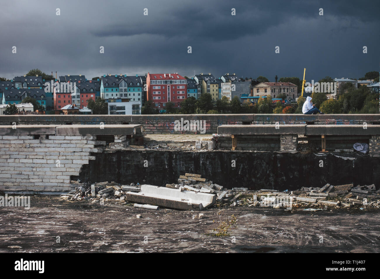 A person sits atop a broken section of the abandoned Tallinn City Hall (Linnahall), completed in 1980 while under Soviet rule Stock Photo