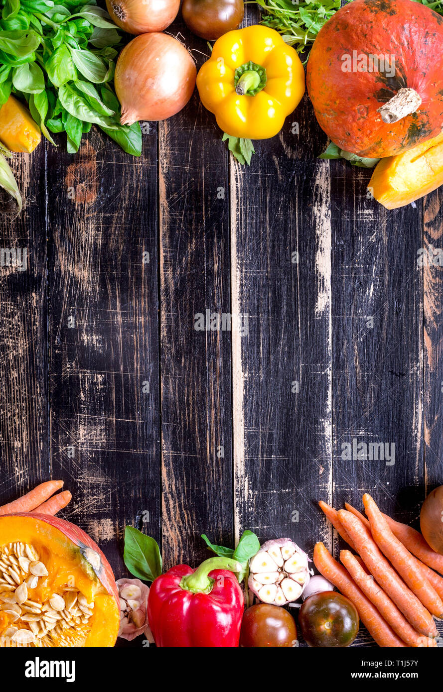 Fresh vegetables on a rustic dark textured table. Autumn background ...