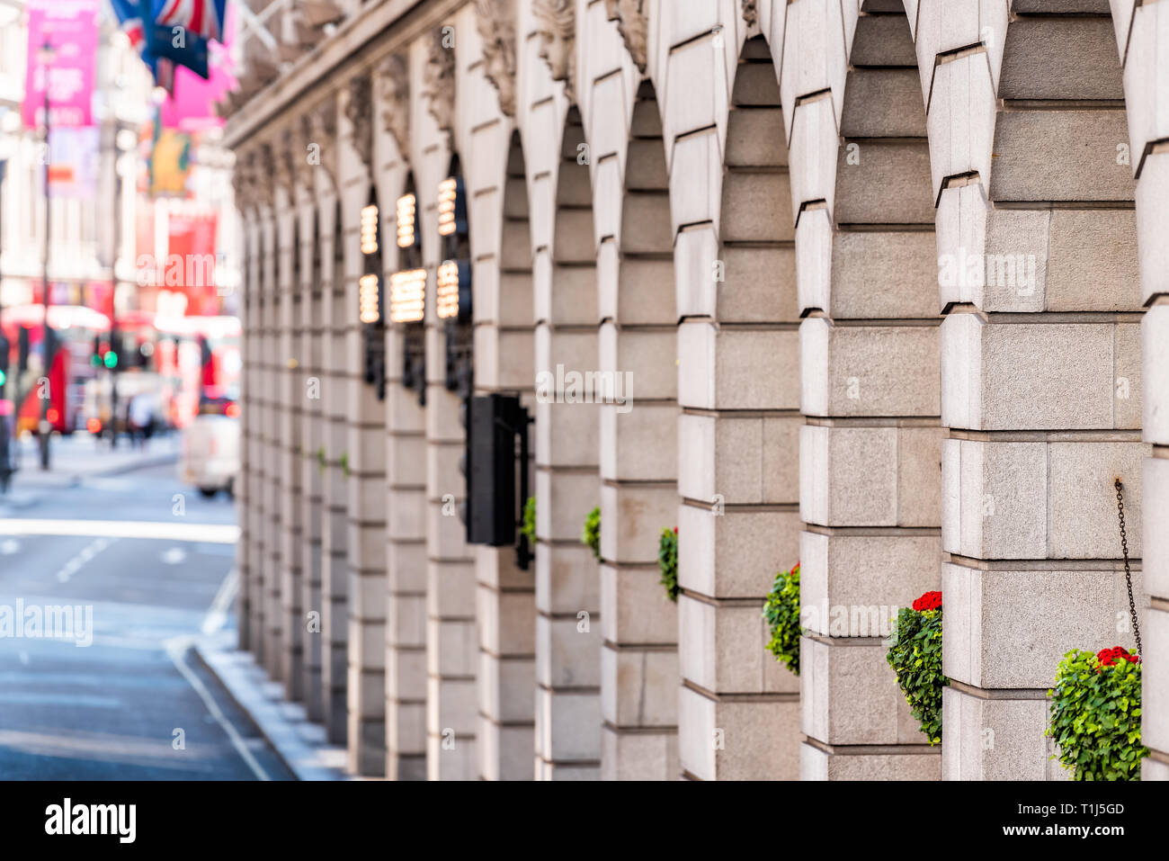 London, UK - June 22, 2018: Piccadilly Circus Regent street architecture with closeup of historic wall summer flower decorations and bokeh blurred bac Stock Photo