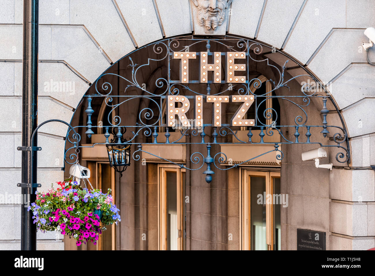 London, UK - June 22, 2018: Piccadilly Circus Regent street with closeup of sign entrance to the Ritz hotel with hanging basket flower decoration in s Stock Photo