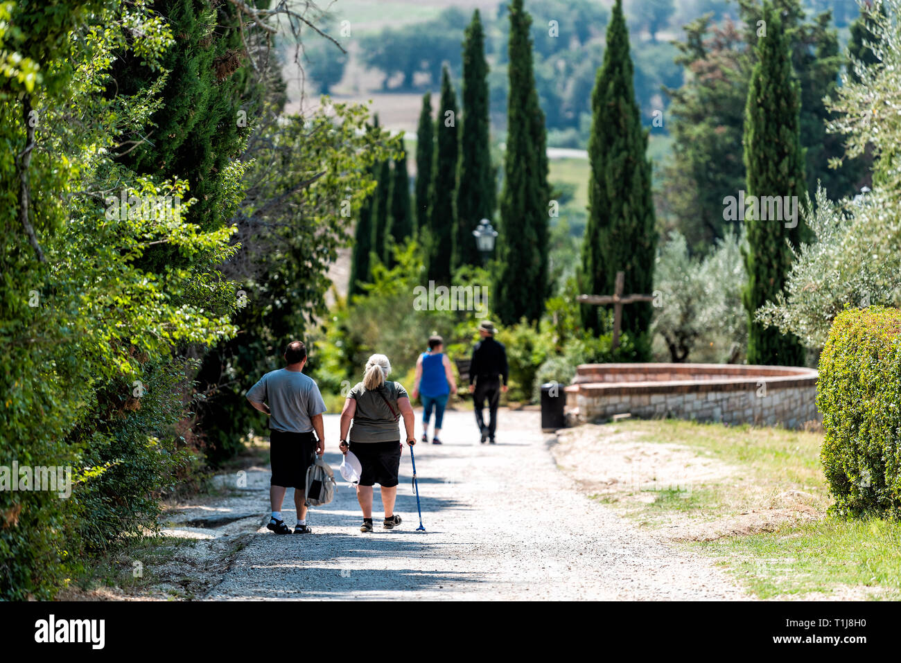 Assisi, Italy - August 29, 2018: Village city in Umbria with road path near San Damiano church during sunny summer day and people walking Stock Photo