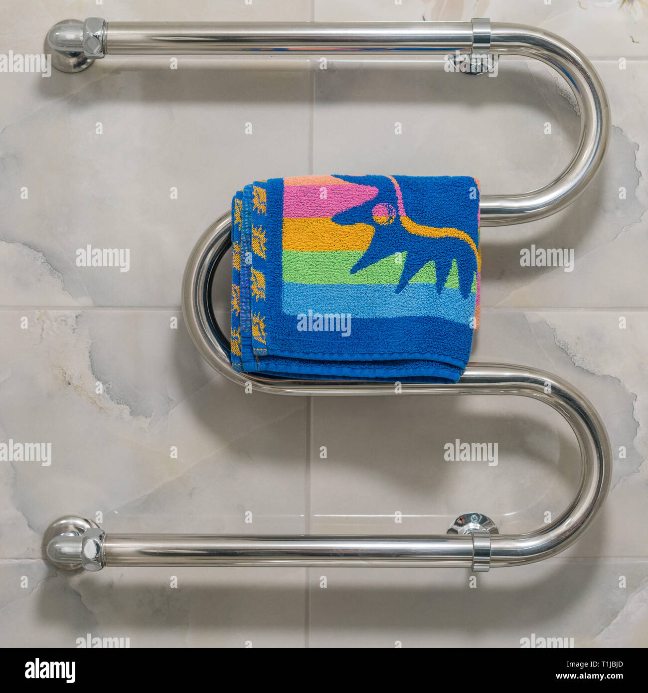 Heated towel rail with color towel Stock Photo Alamy
