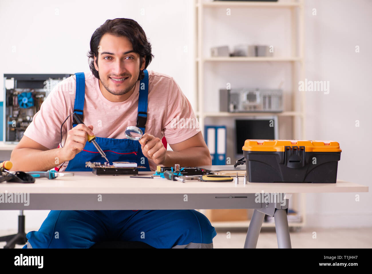Young male contractor repairing computer Stock Photo