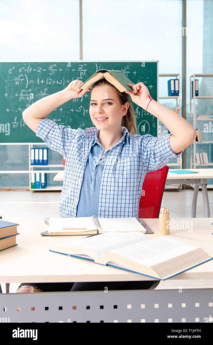 Female student with many books sitting in the classroom Stock Photo - Alamy