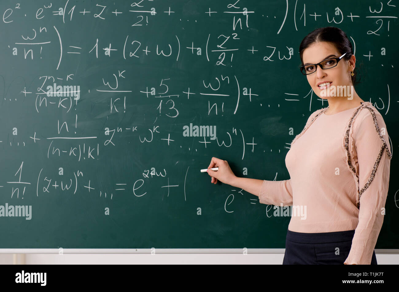 Female teacher standing in front of chalkboard Stock Photo - Alamy