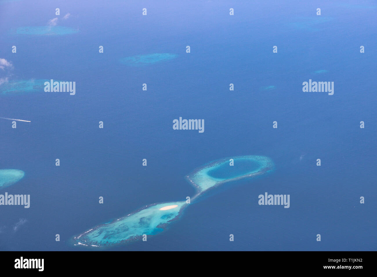 This unique image shows the Maldives photographed from a plane from above. You can see the atolls in the sea well. Stock Photo