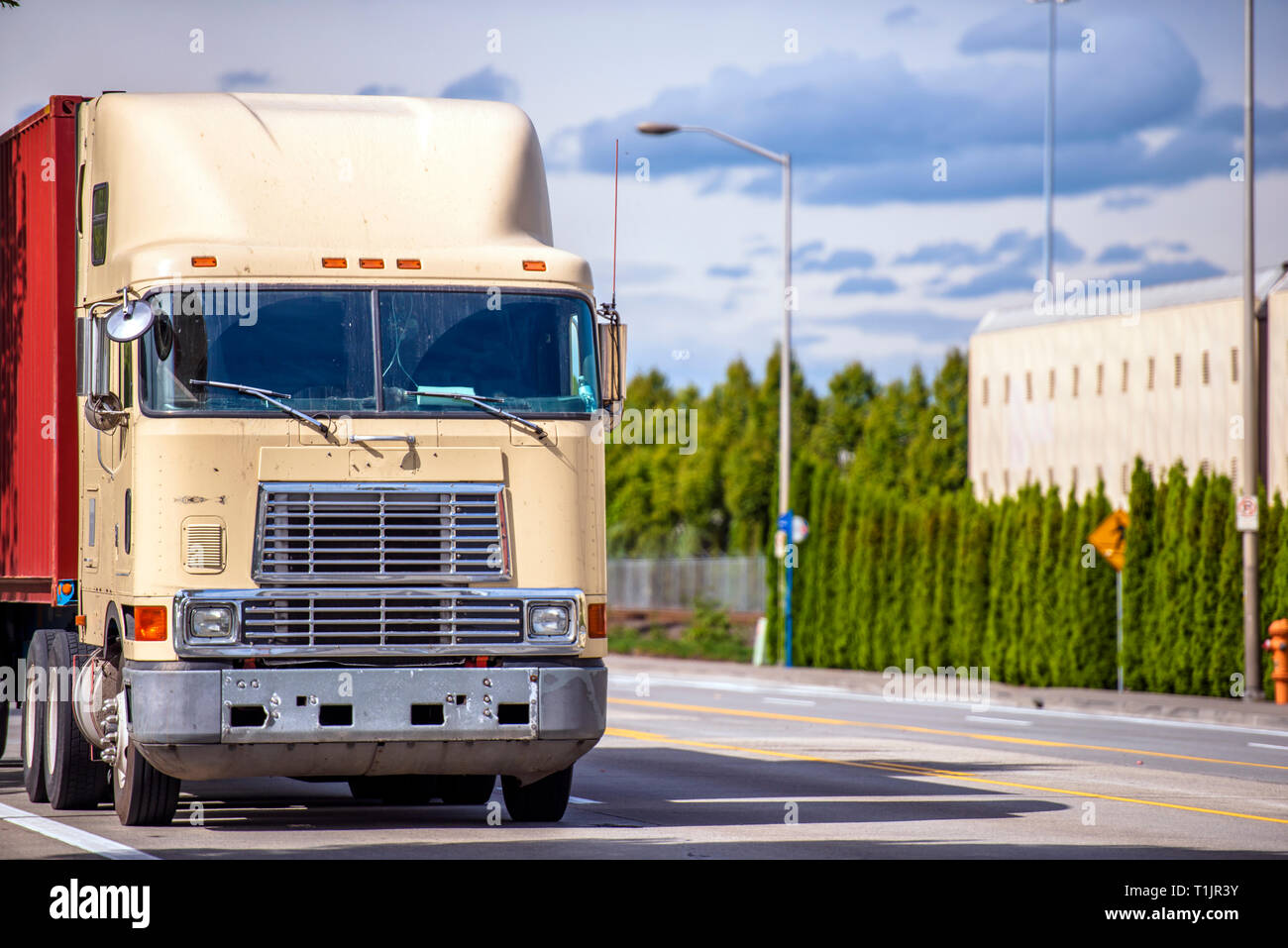 Old fashion bonnet cab-over professional big rig semi truck with roof  spoiler transporting container on flat bed semi trailer running on the  marked ro Stock Photo - Alamy