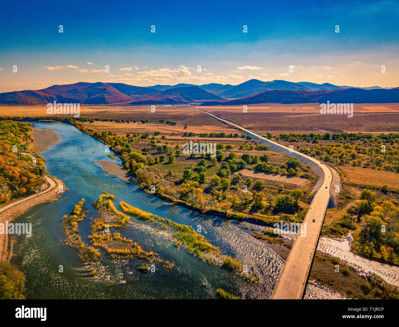 Aerial photograph of meandering river against mountains and grasslands