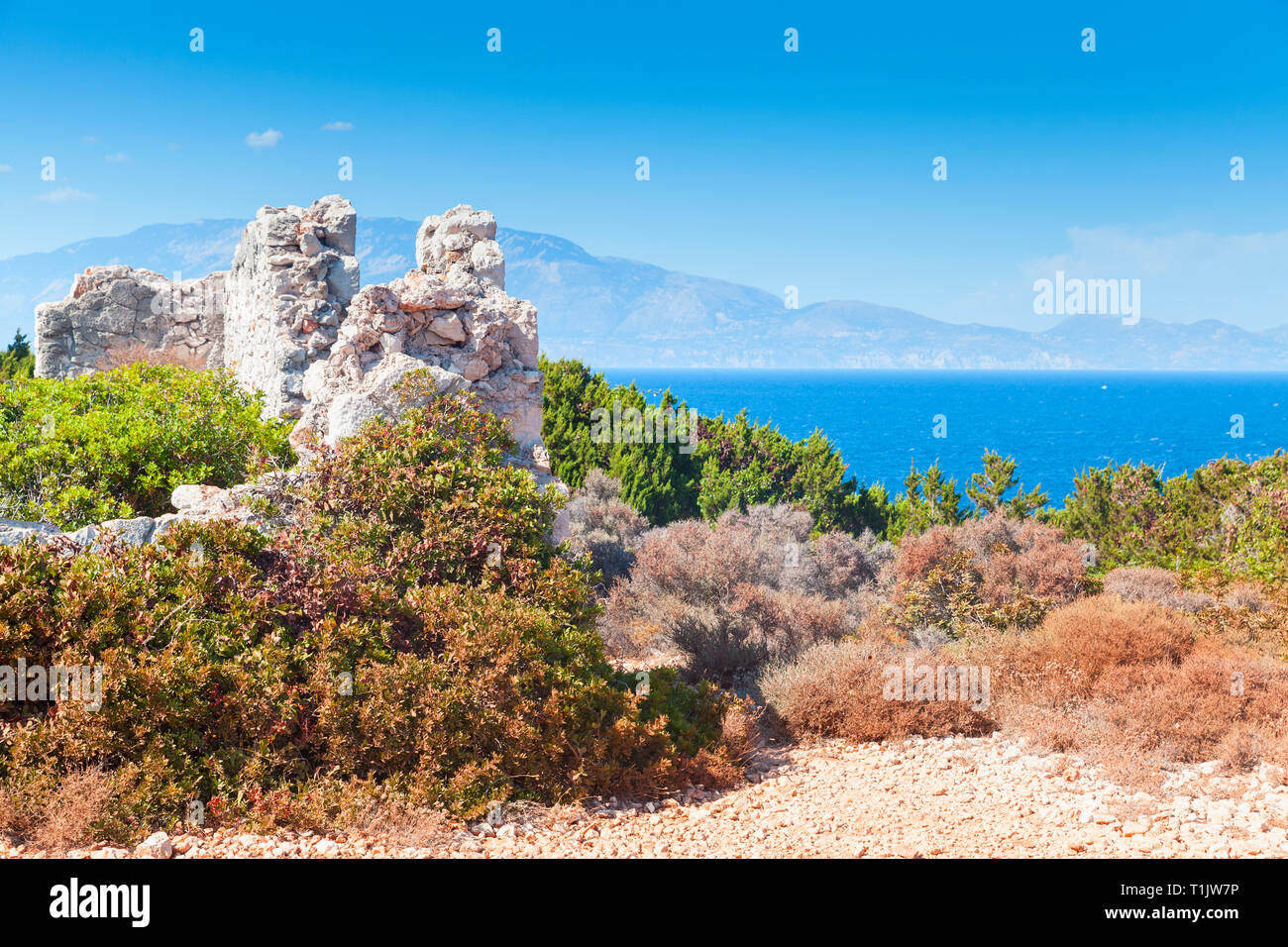 Summer landscape with ruins of white stone house. Zakynthos, Greek island in the Ionian Sea Stock Photo