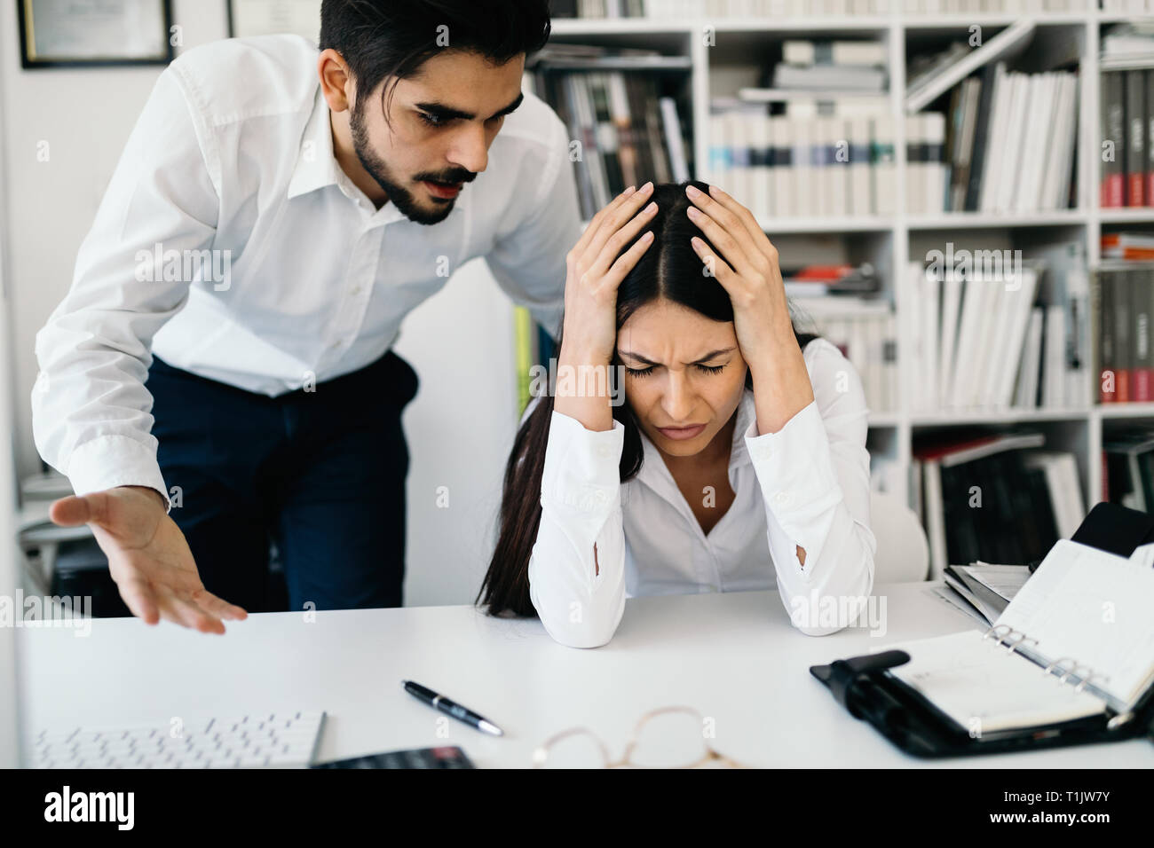 Businessman yelling at female colleague in office Stock Photo