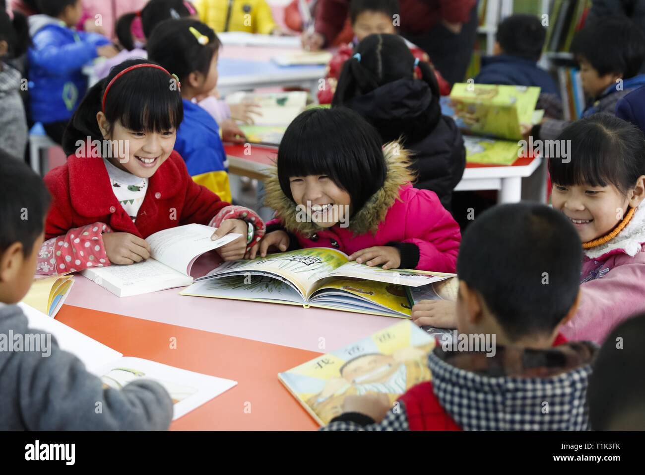 (190327) -- BEIJING, March 27, 2019 (Xinhua) -- Students read books during a reading lesson at Quyang Primary School in Yudu County, east China's Jiangxi Province, Feb. 23, 2017. China's efforts to promote the 'balanced development' of compulsory education, which usually means narrowing inter-regional, rural-urban or inter-school gaps in terms of education conditions and quality, has borne fruit, the Ministry of Education said Tuesday.     According to the ministry, the balanced development of compulsory education has been achieved in 2,717 counties, representing 92.7 percent of counties acros Stock Photo