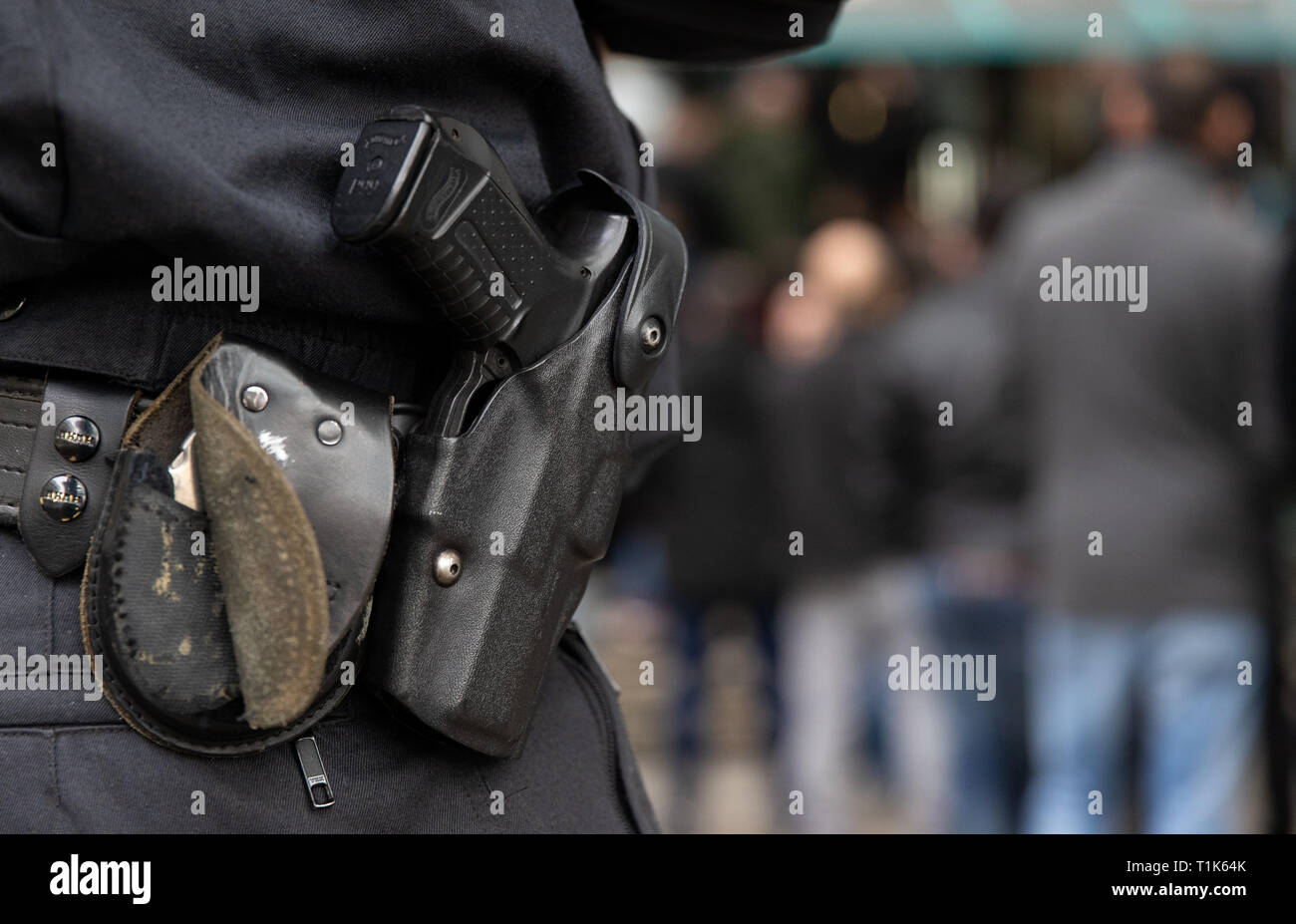Bielefeld, Germany. 27th Mar, 2019. The weapon of a policeman standing before the district court. A trial against eight men on suspicion of a serious breach of the peace begins under great security precautions. The defendants, aged between 20 and 38, are to belong to an extended family. After an argument, one of the men was expelled from a discotheque. The 27-year-old is said to have called his brother and other relatives to it. The argument escalated. Credit: Friso Gentsch/dpa/Alamy Live News Stock Photo
