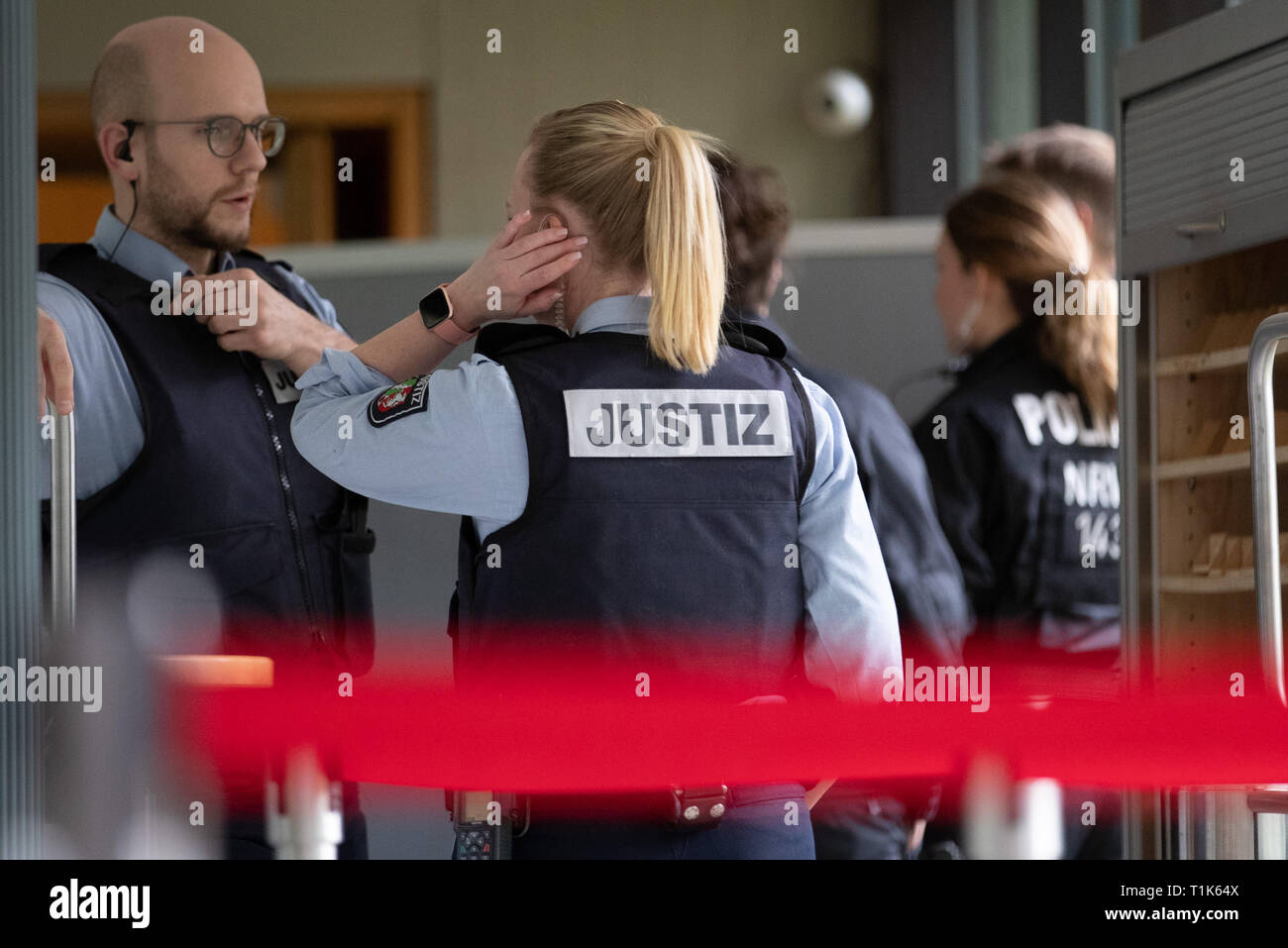 Bielefeld, Germany. 27th Mar, 2019. Judicial officers are standing outside a security perimeter in the county court. A trial against eight men on suspicion of a serious breach of the peace begins under great security precautions. The defendants, aged between 20 and 38, are to belong to an extended family. After an argument, one of the men was expelled from a discotheque. The 27-year-old is said to have called his brother and other relatives to it. The argument escalated. Credit: Friso Gentsch/dpa/Alamy Live News Stock Photo