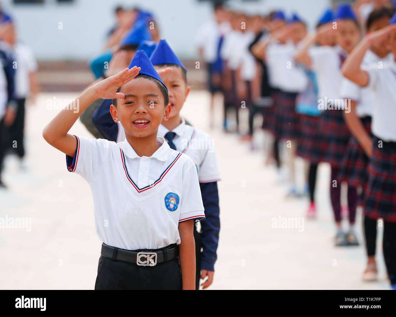 Vientiane. 22nd Mar, 2019. Students salute while the national flag is being lowered at China-Laos Friendship School in Muang Xay of Laos, March 22, 2019. TO GO WITH Feature Chinese school in northern Laos contributes to cultural exchanges, local development Credit: Wang Jingqiang/Xinhua/Alamy Live News Stock Photo