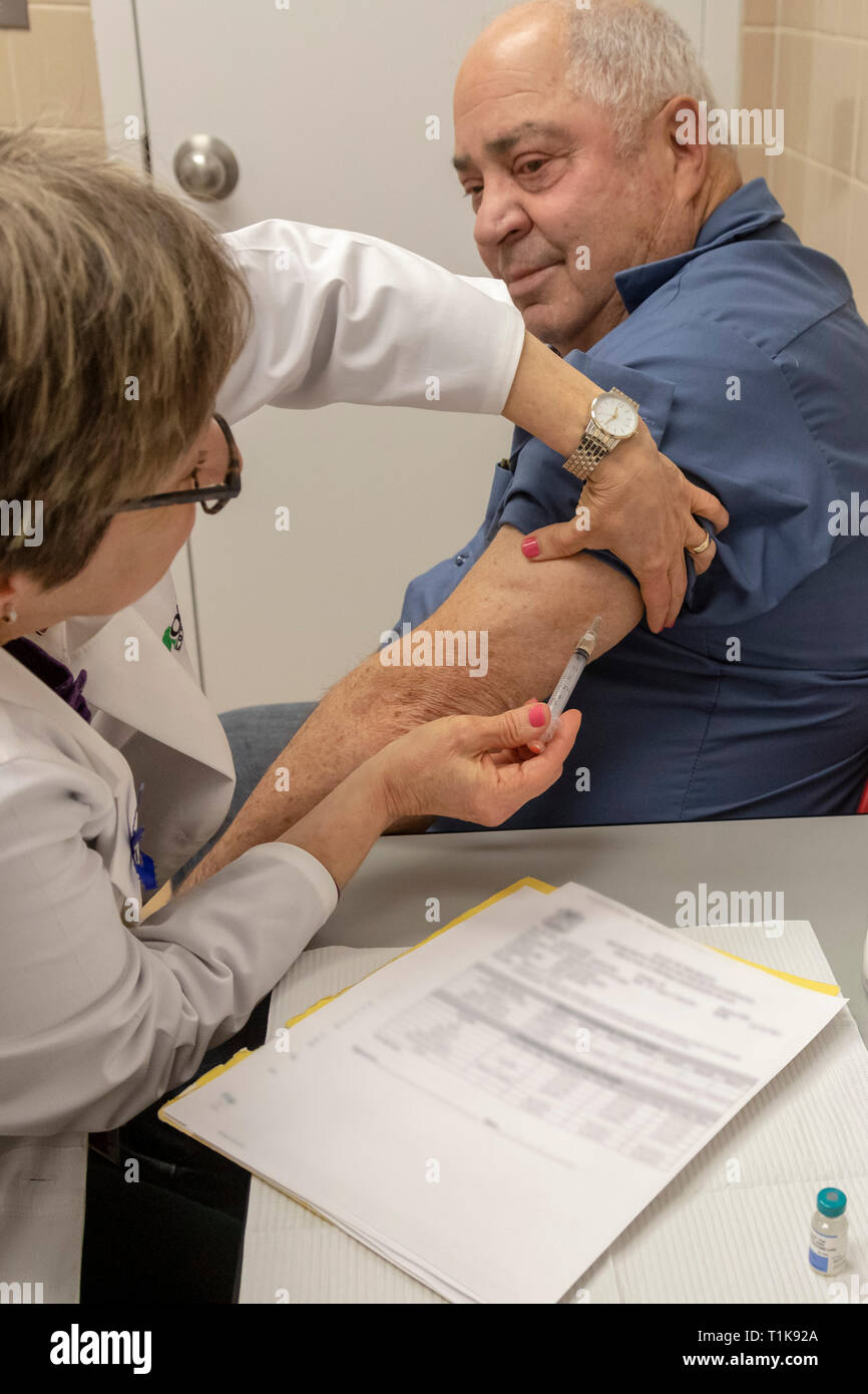 Southfield, Michigan, USA. 27th Mar, 2019. Abraham Gontovnik, 72, gets the MMR vaccine at the Oakland County Health Department to protect him against a measles outbreak. Twenty-two measles cases have been confirmed in the area since the visit of an infected traveler from Israel. Nurse Fran McClish administers the shot. Credit: Jim West/Alamy Live News Stock Photo