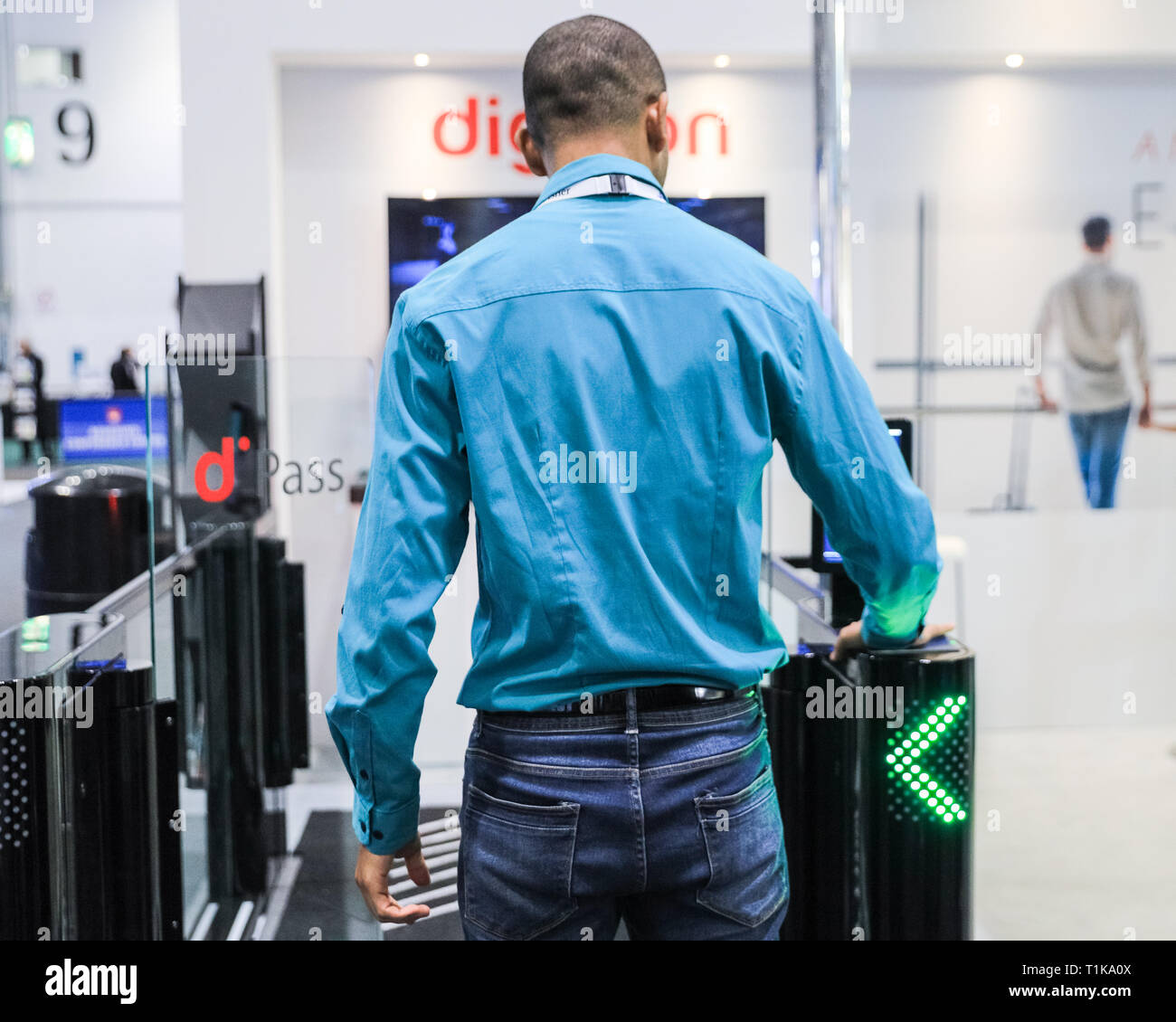 ExCel, London, UK. 27th Mar, 2019. A representative at the digicon stand demonstrates walking through the d'pass access control gates. The Passenger Terminal Expo 2019 brings together exhibitors and trade visitors to see the latest new technologies and product launches from more than 350 of the airport world's leading solution providers. Credit: Imageplotter/Alamy Live News Stock Photo