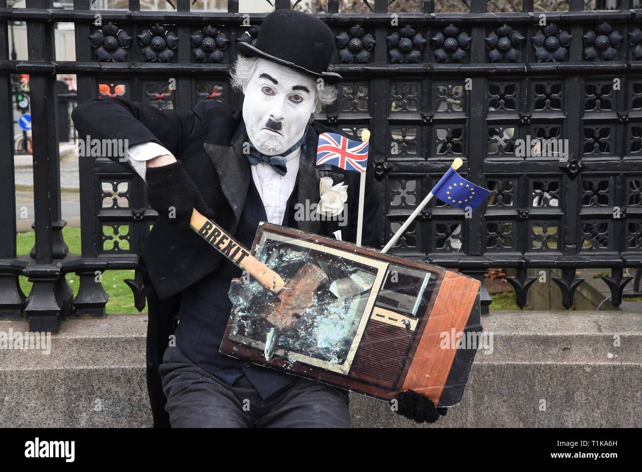 Westminster, London, UK. 27th Mar 2019. Remain Protester. A Charlie Chaplin actor 'smashes' a TV with a hammer marked Brexit. Houses of Parliament, Westminster, London. UK Credit: michael melia/Alamy Live News Stock Photo