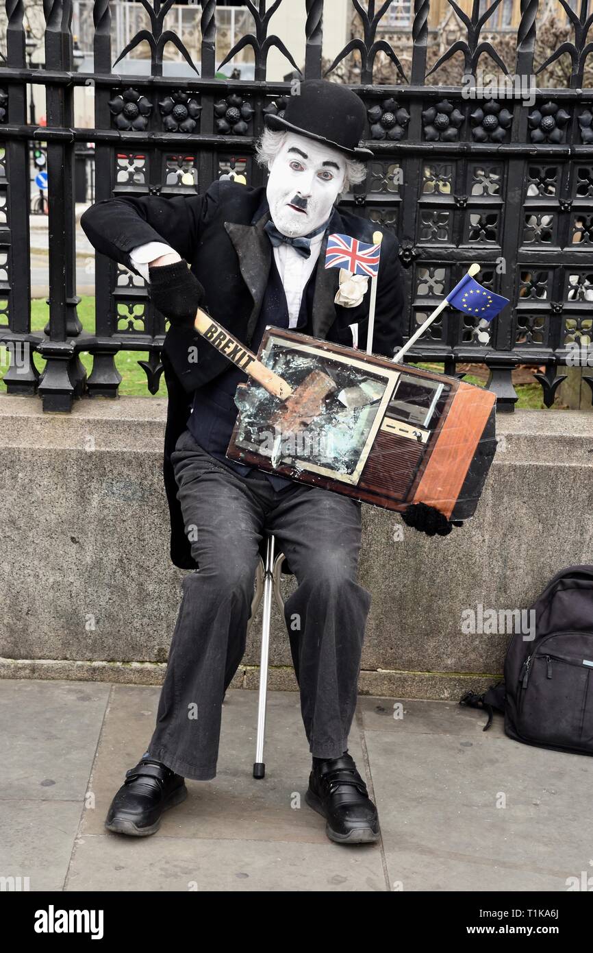 Westminster, London, UK. 27th Mar 2019. Remain Protester. A Charlie Chaplin actor 'smashes' a TV Screen with a hammer marked Brexit. Houses of Parliament, Westminster, London. UK Credit: michael melia/Alamy Live News Stock Photo