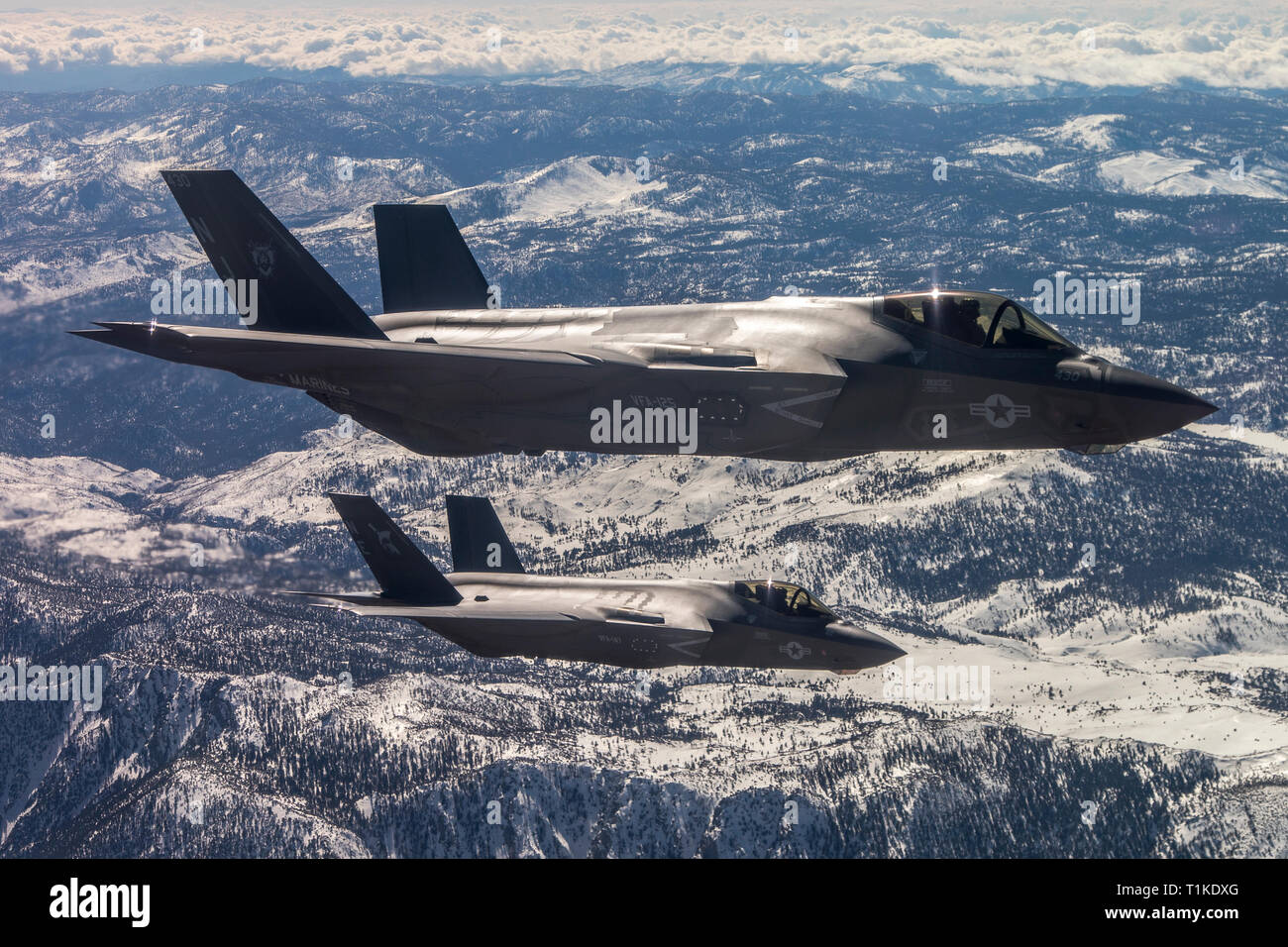 U.S. Navy F-35C Lightning II stealth fight aircraft with Strike Fighter Squadron 125 fly in formation over the Sierra Nevada mountains during a training exercise February 28, 2019 over Lemoore, California. Stock Photo