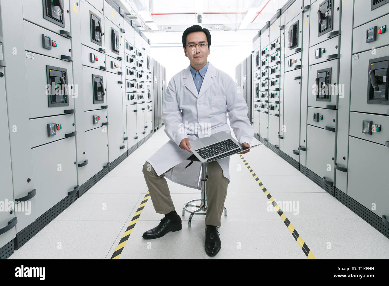 Technical personnel in the voltage room work Stock Photo
