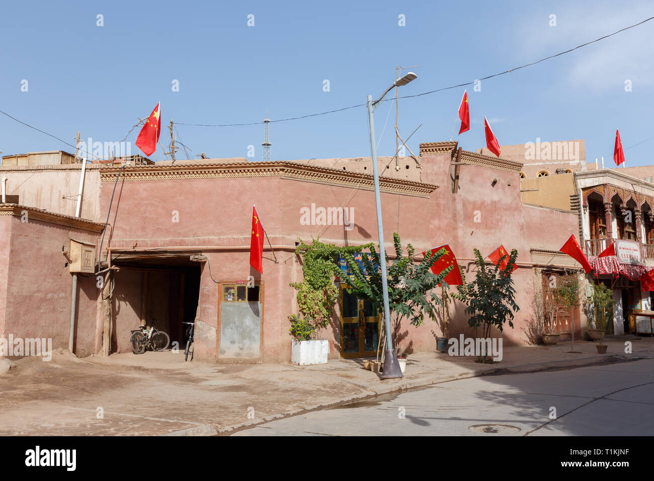 Corner house in Kashgar Old Town with Chinese flags on each and every corner (Xinjiang Province, China) Stock Photo