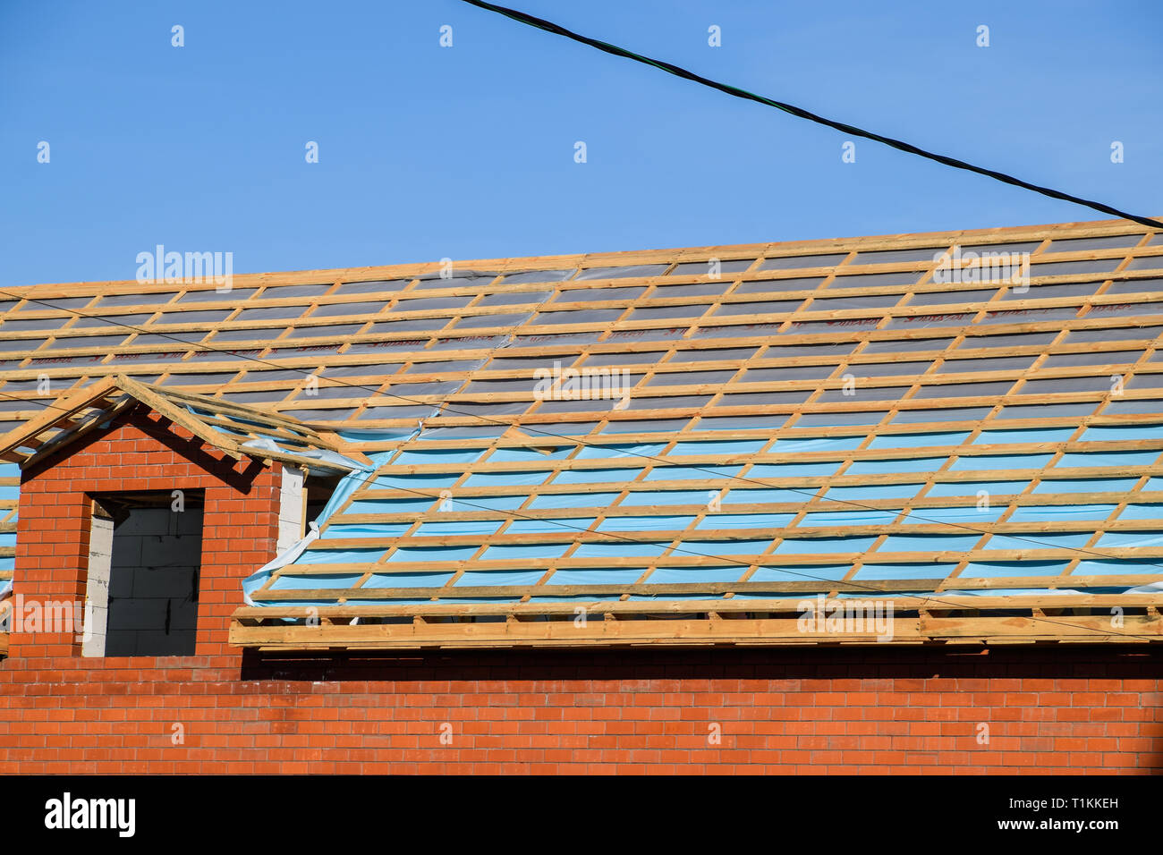 Construction of the roof of a new house. Wooden bars and vapor barrier