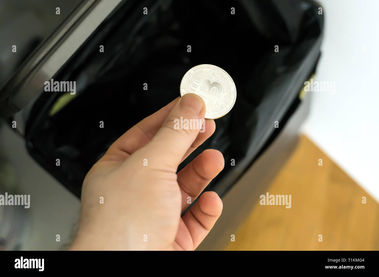 Man throws a bitcoin coin in the trash bin Stock Photo Alamy