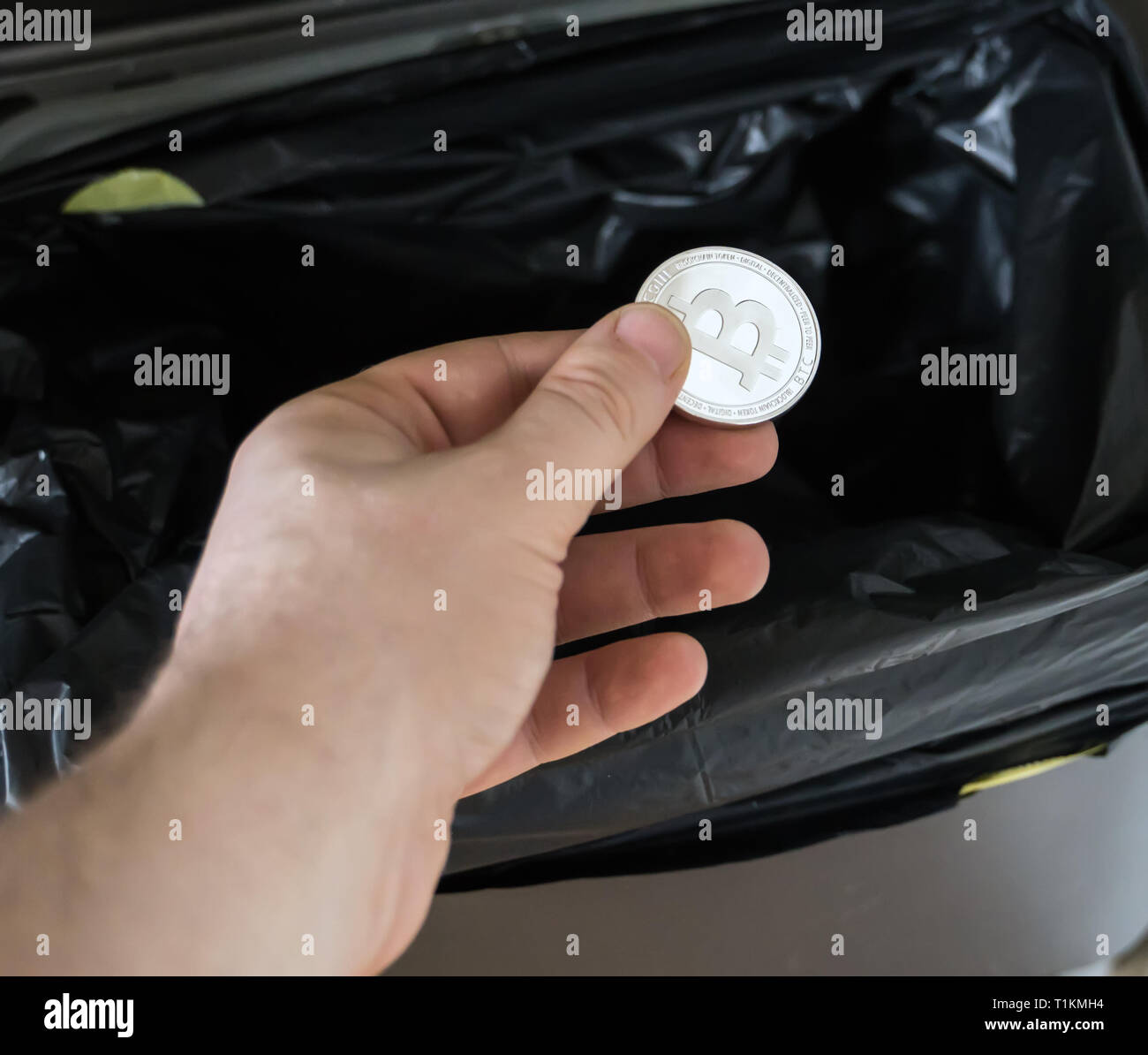 Man throws a bitcoin coin in the trash bin Stock Photo Alamy