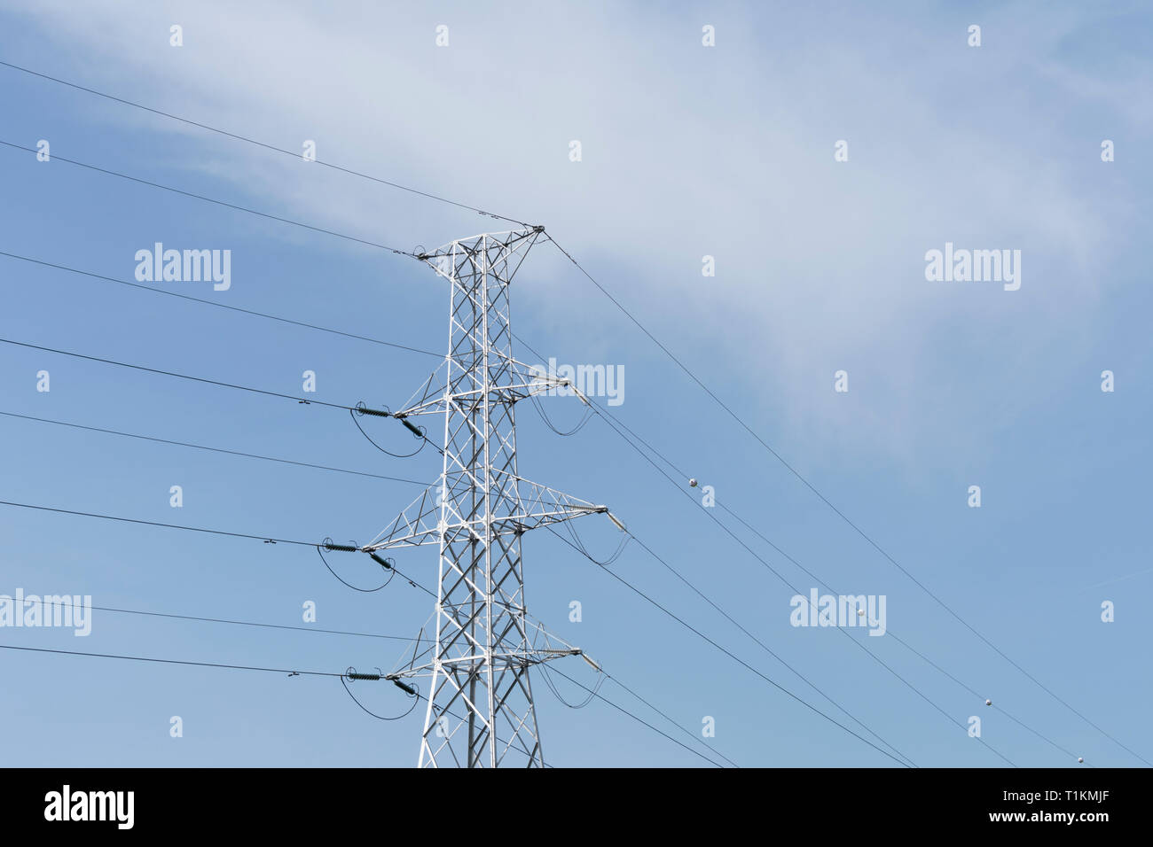 Blue Sky with white clouds and an electric tower with a cable connection Stock Photo