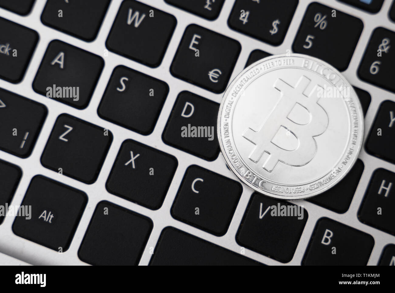 Silver bitcoin coin cryptocurrency on the laptop keyboard Stock Photo ...