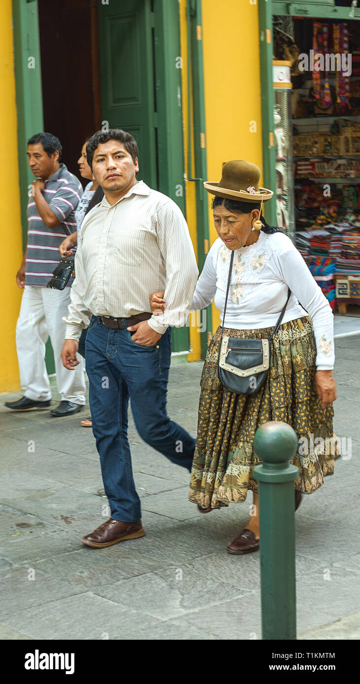 Lima, Peru - 27.12.2018. Couple of man and old woman, people in modern and traditional clothes on the street of Lima, capital Peru, Latin America. Stock Photo