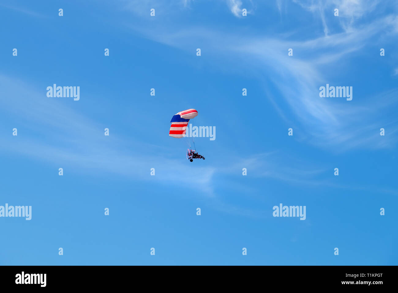 Pilot hang gliding on a blue sky  background. Stock Photo