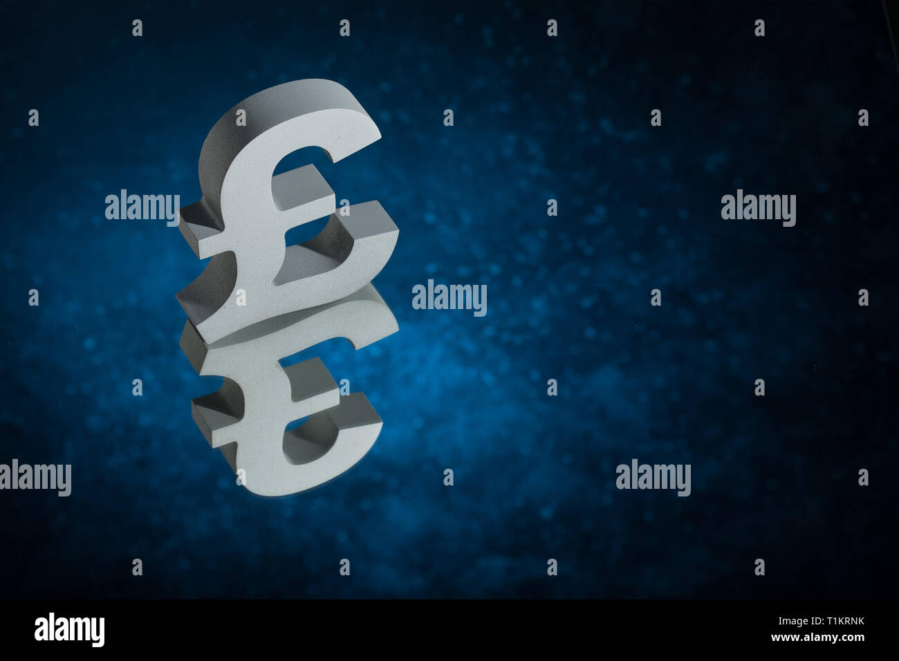 British Currency Symbol or Sign Pound With Mirror Reflection on Blue Dusty Background Stock Photo