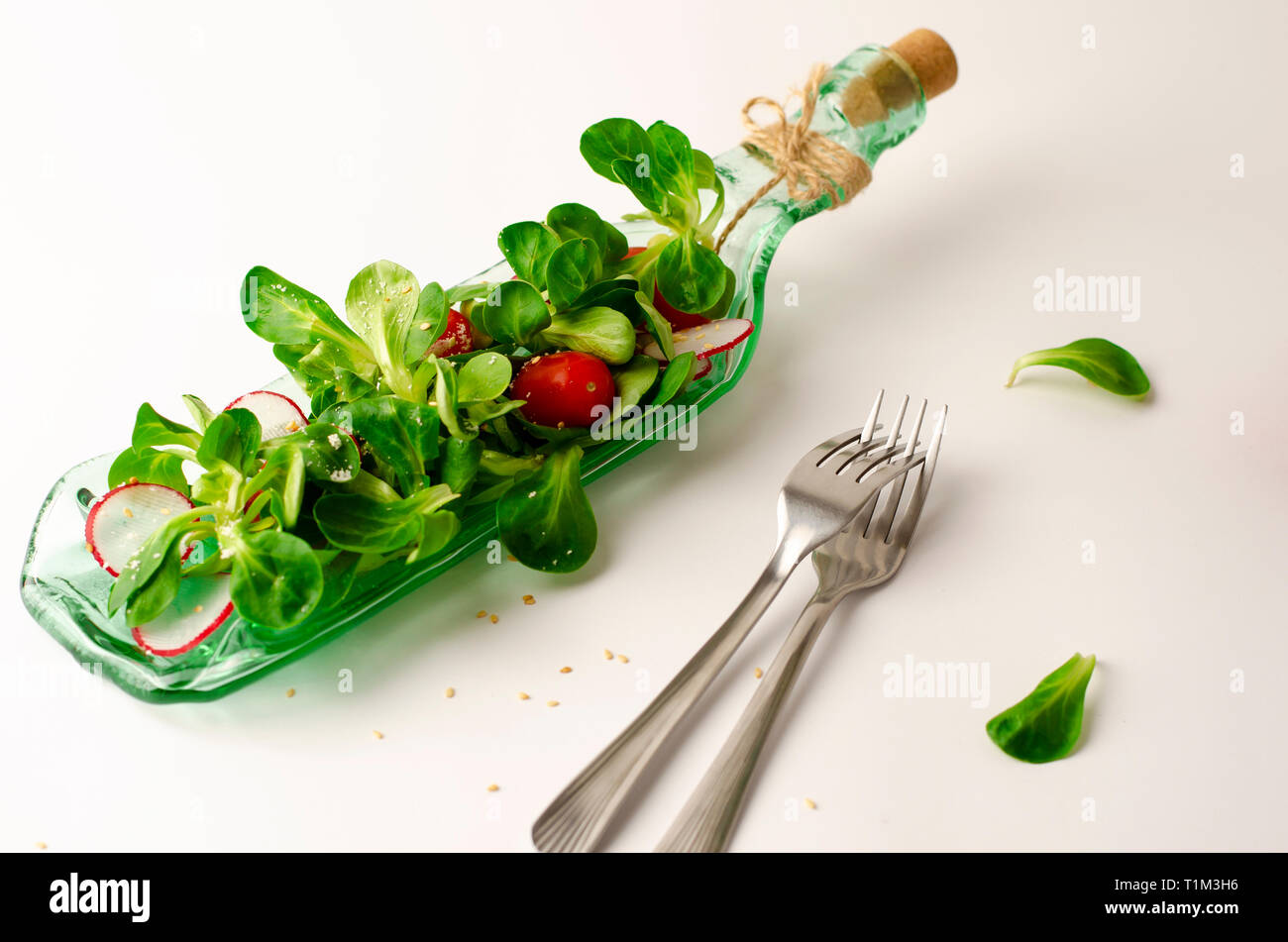 Healthy breakfast or lunch. Fresh vegetable salad of radish, tomatoes and corn salad or Valerianella locusta. Close up on white plate. Diet and vegeta Stock Photo