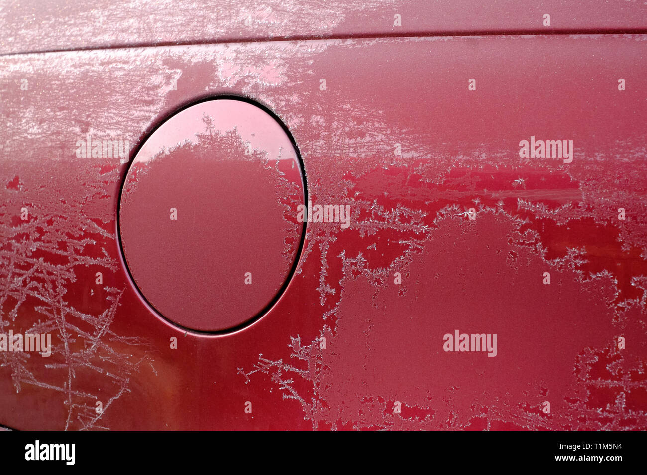 ice crystals from a hard frost on a car fuel filler cap concept of a fuel price freeze Stock Photo